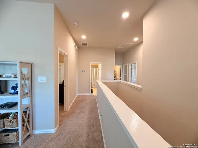 a view of a hallway with wooden floor and cabinet
