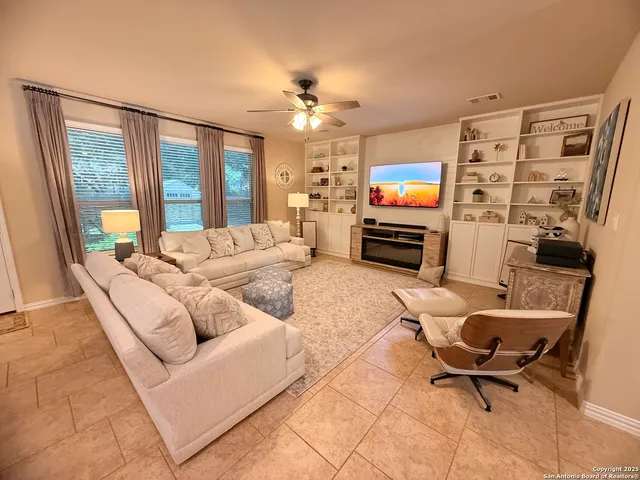 a living room with furniture a flat screen tv and a large window