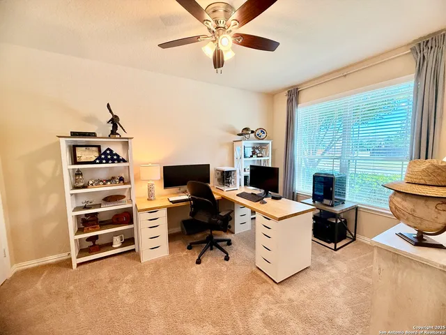 a view of a workspace with furniture and a window