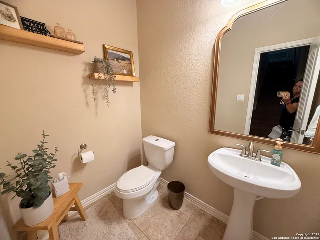 a bathroom with a toilet sink and mirror