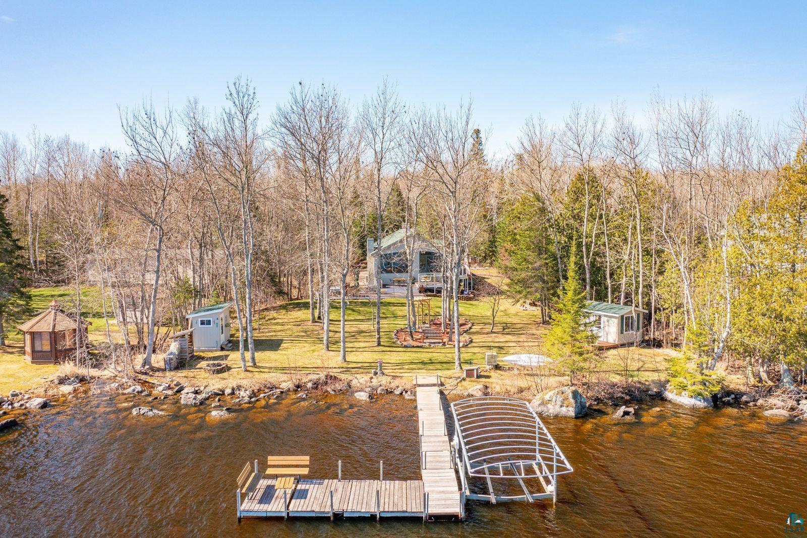 4452 Moccasin Point Road Tower, MN 55790 - Photo 41 of 44 Waterfront property featuring a wood dock with a built-in bench, a covered boat slip, a gazebo, and two additional outdoor structures