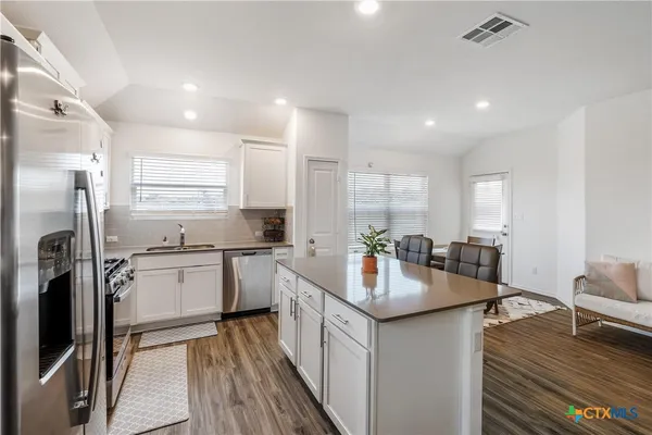 a kitchen with sink cabinets and refrigerator