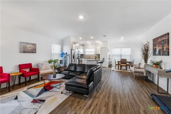 a living room with furniture and wooden floor