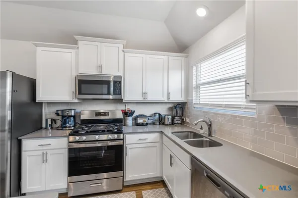 a kitchen with a sink stove and microwave