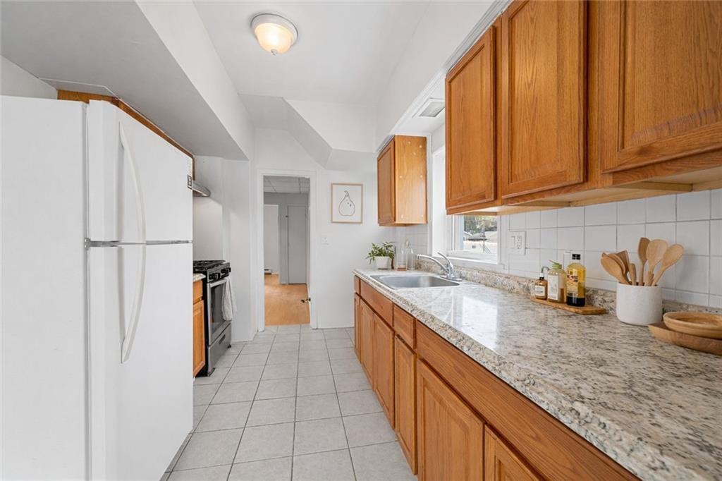 883 Manor Road Staten Island, NY 10314 - Photo 11 of 24 a kitchen with sink a refrigerator and cabinets