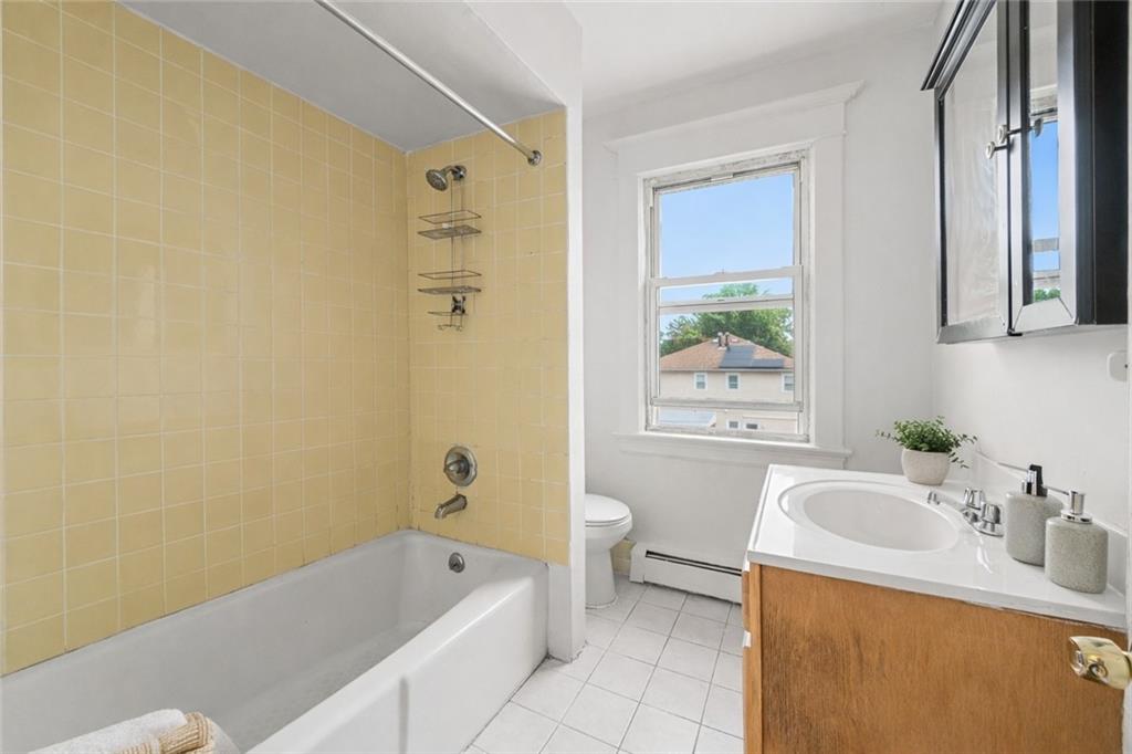883 Manor Road Staten Island, NY 10314 - Photo 12 of 24 a bathroom with a tub a sink a window and a shower