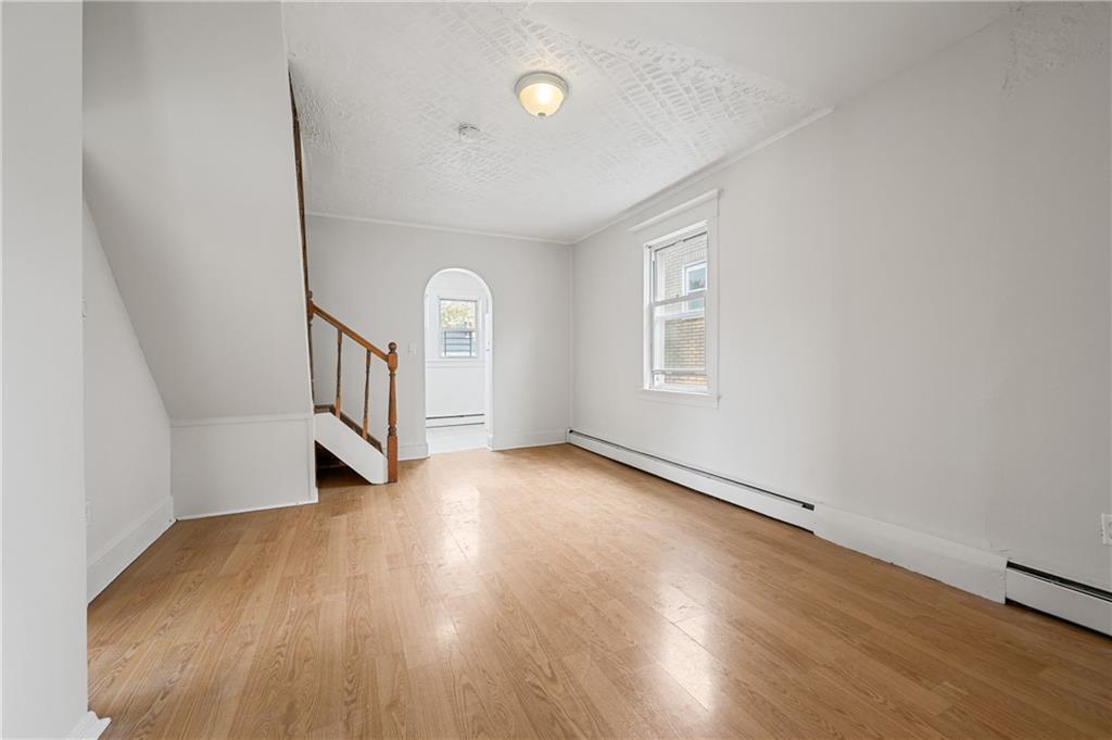 883 Manor Road Staten Island, NY 10314 - Photo 17 of 24 a view of an empty room with wooden floor and a window