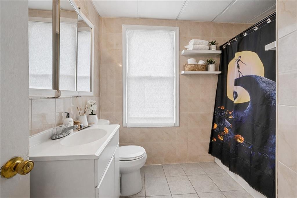 883 Manor Road Staten Island, NY 10314 - Photo 10 of 24 a bathroom with a sink and mirror with toilet