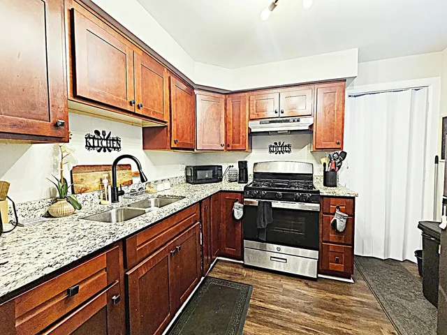 a kitchen with stainless steel appliances granite countertop a stove and a sink