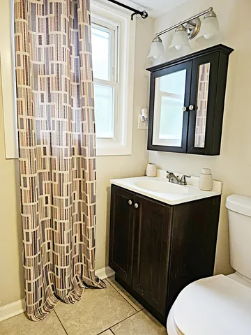 a bathroom with a sink vanity mirror and toilet