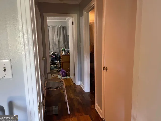 a view of a hallway with wooden floor and closet
