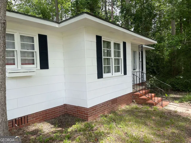 a view of house with backyard and glass windows