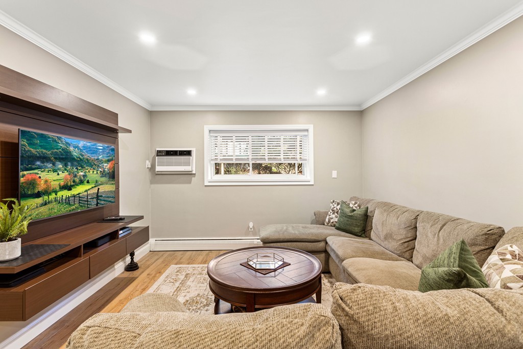412 Langley Road, Unit 3 Newton, MA 02459 - Photo 15 of 30 a living room with furniture a flat screen tv and a window