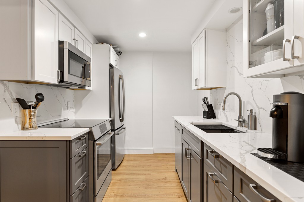 412 Langley Road, Unit 3 Newton, MA 02459 - Photo 4 of 30 a kitchen with stainless steel appliances granite countertop a sink stove and refrigerator