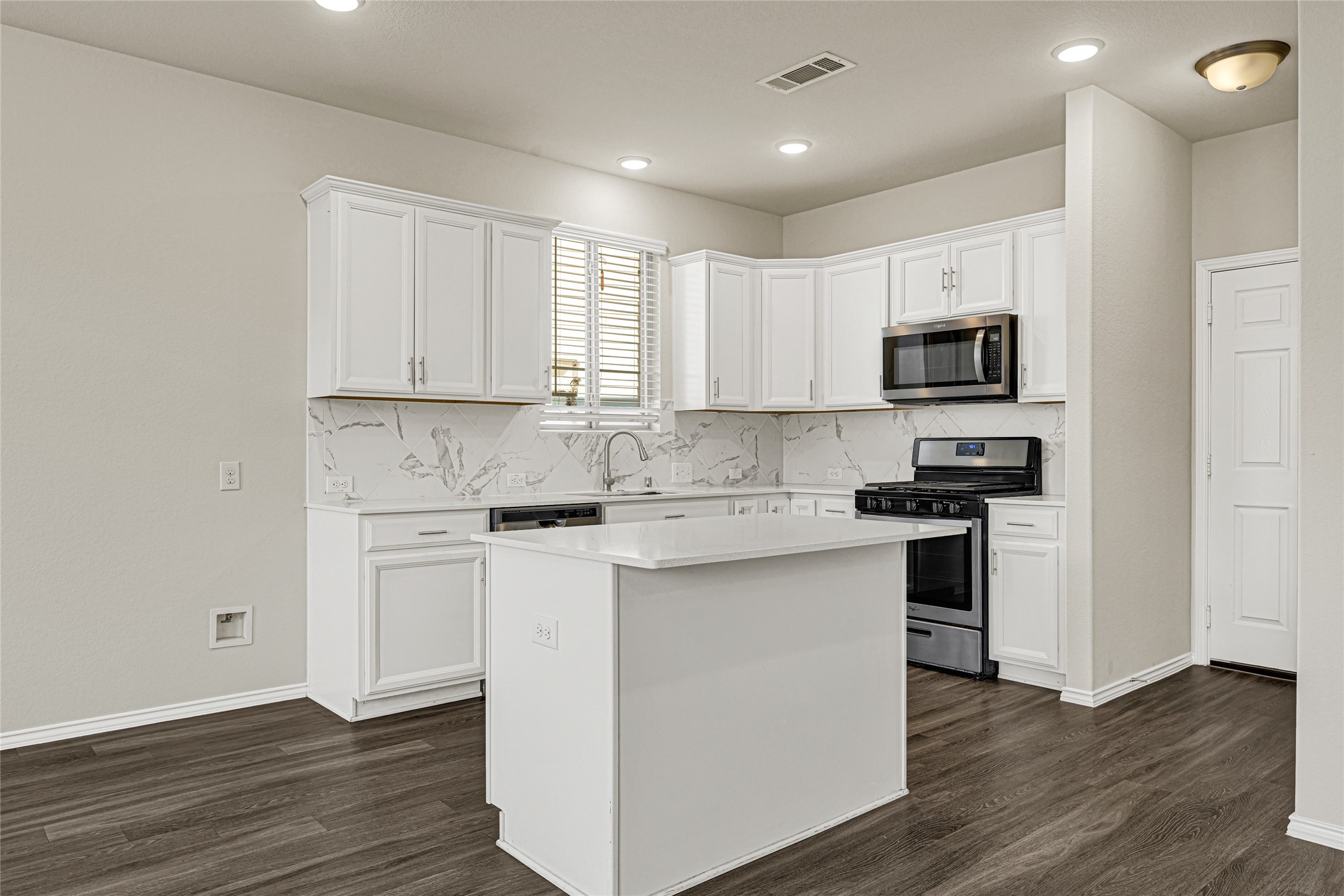 2210 Timberland Country Court Conroe, TX 77304 - Photo 11 of 25 a kitchen with stainless steel appliances granite countertop a stove top oven a sink a refrigerator and white cabinets with wooden floor