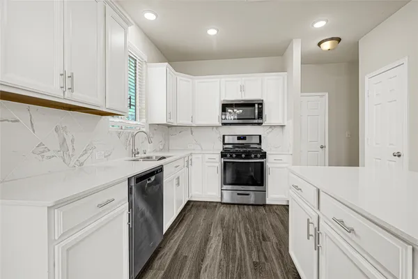 a kitchen with stainless steel appliances white cabinets and a sink