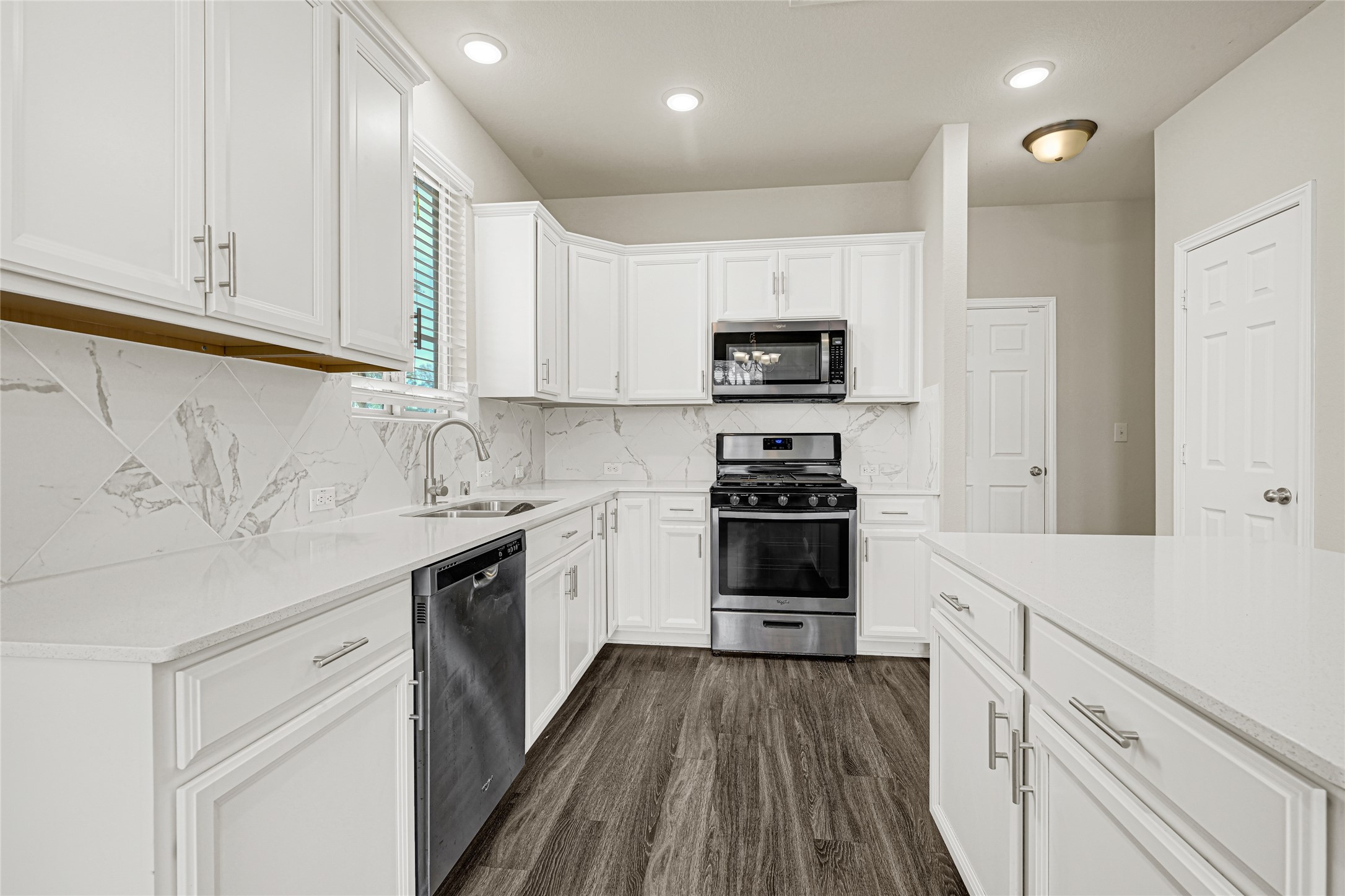 2210 Timberland Country Court Conroe, TX 77304 - Photo 12 of 25 a kitchen with stainless steel appliances white cabinets and a sink