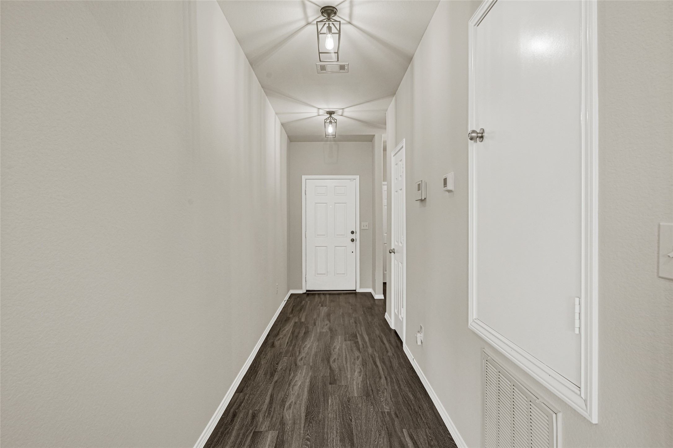 2210 Timberland Country Court Conroe, TX 77304 - Photo 4 of 25 a view of a hallway with wooden floor and a chandelier