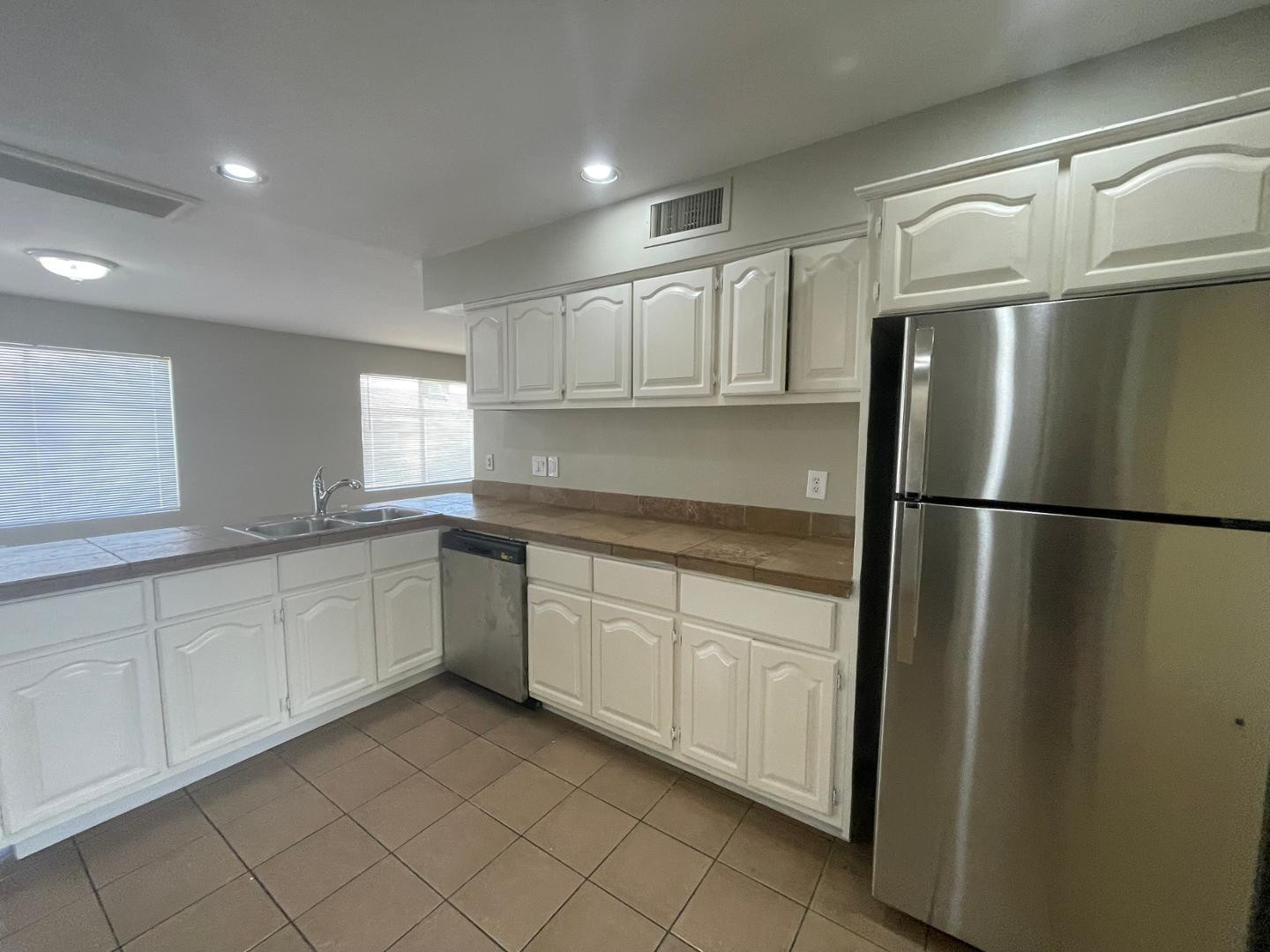 10902 West Montecito Avenue Phoenix, AZ 85037 - Photo 7 of 22 a kitchen with white cabinets and refrigerator