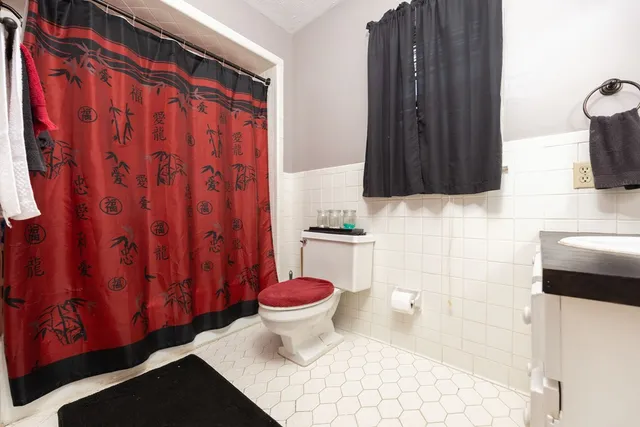a bathroom with a sink a toilet and shower curtain