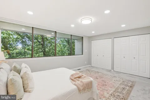 a bedroom with a bed and a large window