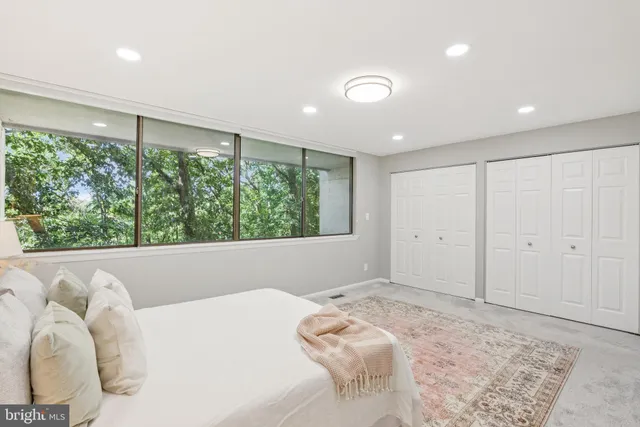 a bedroom with a bed and a large window