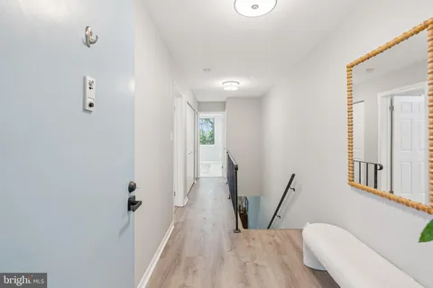 a view of a hallway with furniture and wooden floor