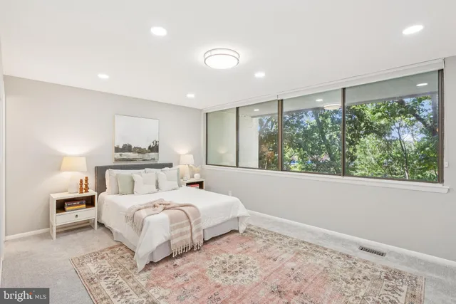 a bedroom with a large bed and a large window