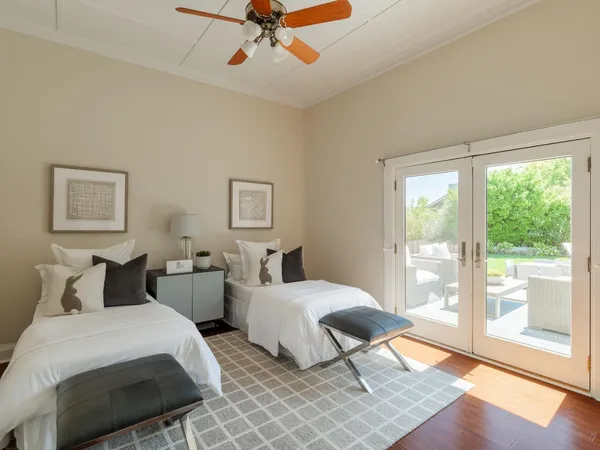 a bedroom with two beds and a large window