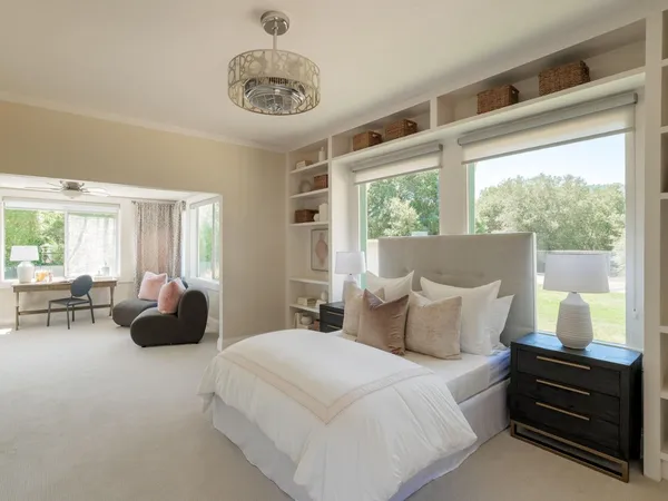 a bedroom with a bed and a large window