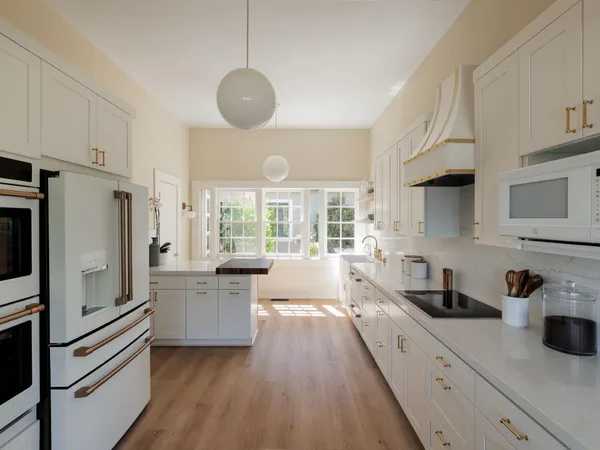 a large kitchen with a large window stainless steel appliances and cabinets