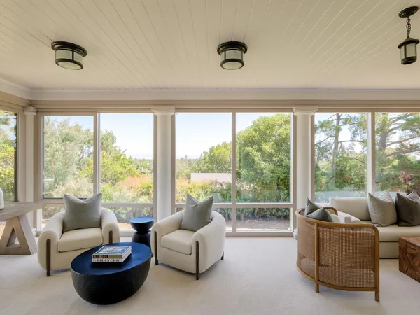 a living room with furniture and a floor to ceiling window