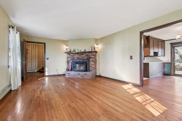 an empty room with wooden floor and fireplace