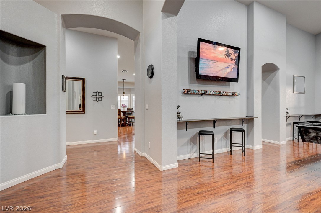 1604 Cattle Ranch Place Henderson, NV 89002 - Photo 13 of 99 Rich hardwood floors flow through arched doorways, creating an open and inviting living space.
