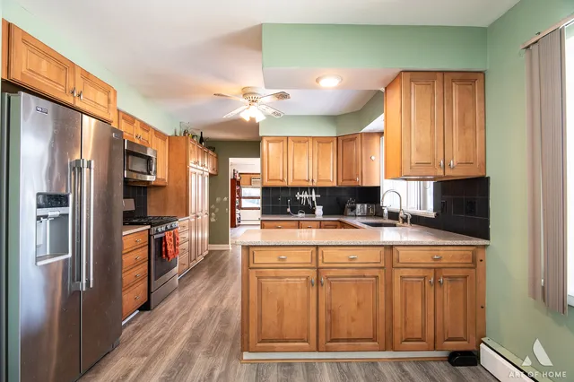 a kitchen with stainless steel appliances granite countertop a refrigerator a stove and a sink