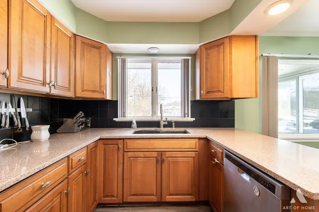 a kitchen with granite countertop a sink a counter space appliances and cabinets