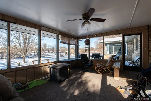 a living room with furniture tv and large windows
