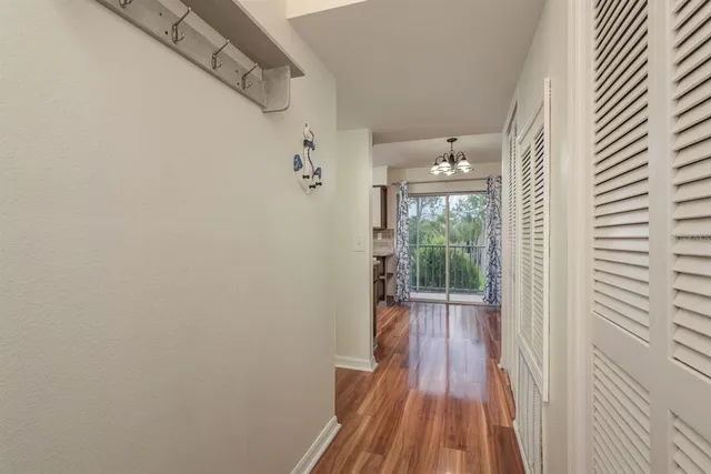 a view of a hallway with wooden floor and a bathroom