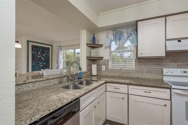 a kitchen with stainless steel appliances granite countertop a sink and a granite counter tops