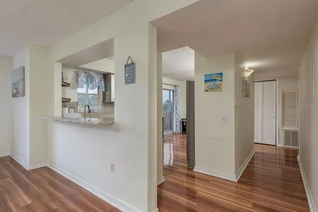 a view of a hallway with wooden floor and a living room