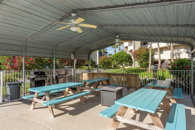 a view of a patio with a dining table and chairs with a small yard