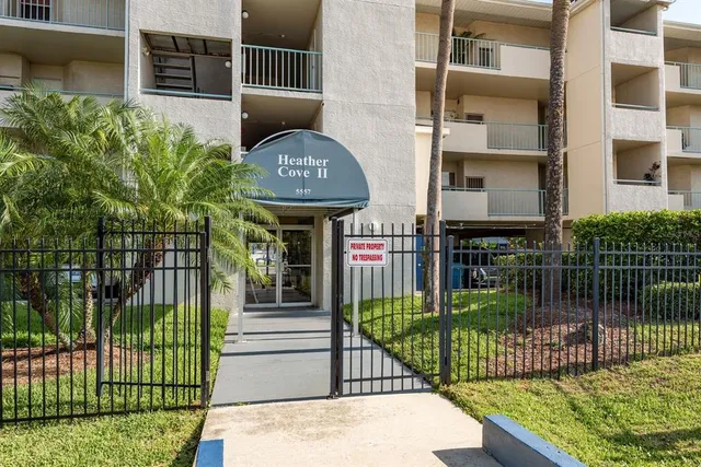 a view of a brick house with a small yard and potted plants