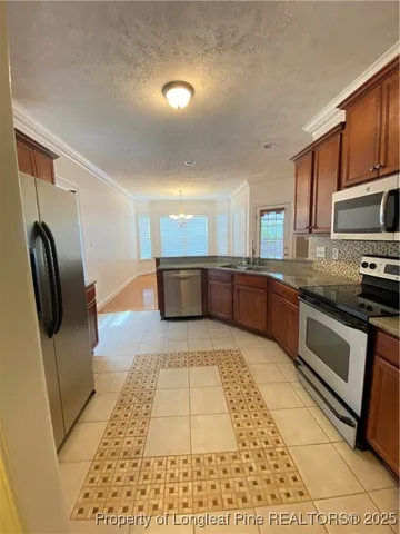 a large kitchen with stainless steel appliances granite countertop a refrigerator and a stove top oven
