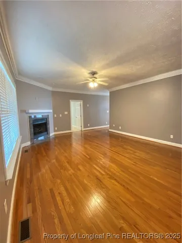 an empty room with wooden floor and fireplace