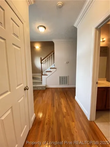 a view of a hallway with wooden floor and staircase