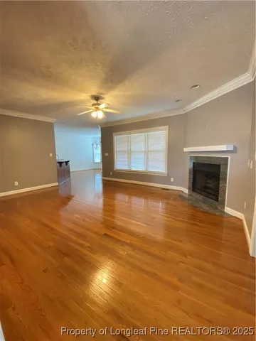 a view of empty room with wooden floor and fireplace