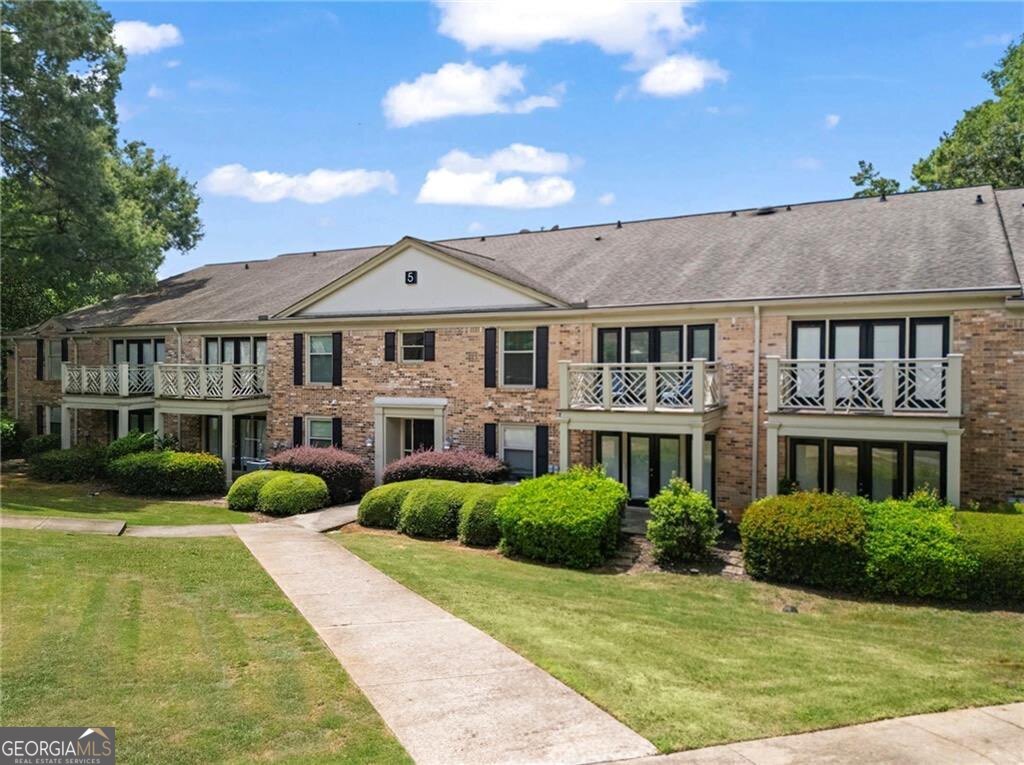 3650 Ashford Dunwoody Road Northeast, Unit 515 Atlanta, GA 30319 - Photo 13 of 14 a view of a white house with a big yard and potted plants