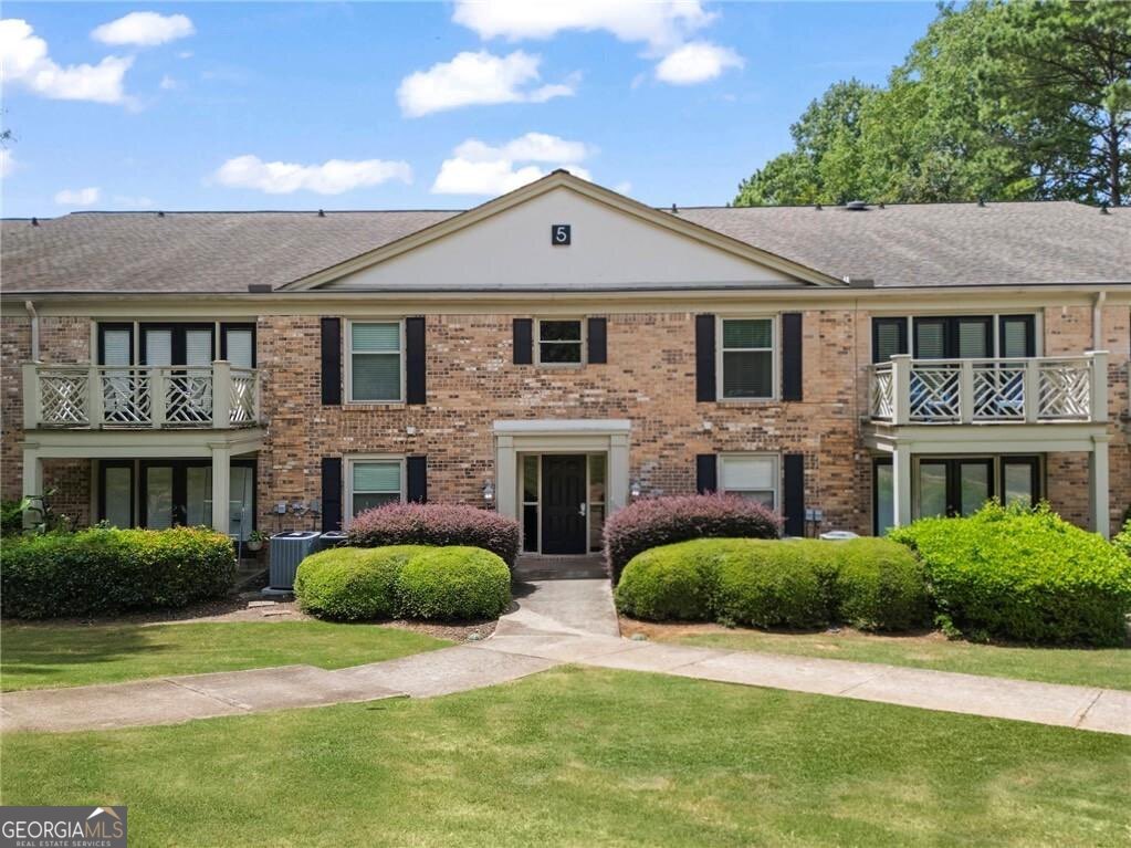 3650 Ashford Dunwoody Road Northeast, Unit 515 Atlanta, GA 30319 - Photo 14 of 14 a front view of a house with a yard and garage