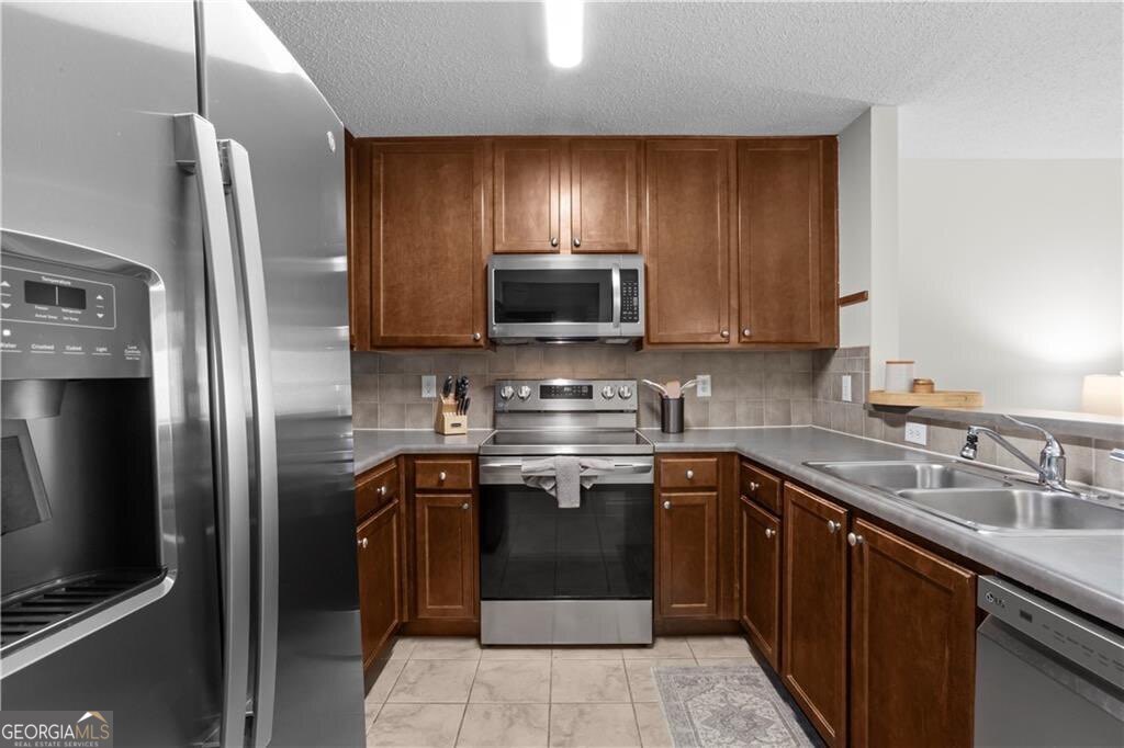 3650 Ashford Dunwoody Road Northeast, Unit 515 Atlanta, GA 30319 - Photo 5 of 14 a kitchen with stainless steel appliances granite countertop a sink stove and refrigerator
