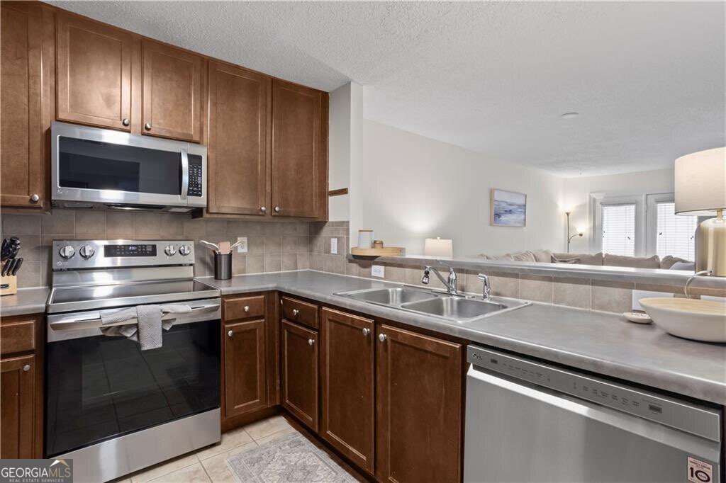 3650 Ashford Dunwoody Road Northeast, Unit 515 Atlanta, GA 30319 - Photo 6 of 14 a kitchen with a sink stove and microwave